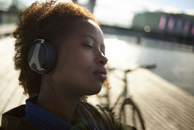 Close-up of relaxed woman with eyes closed listening music