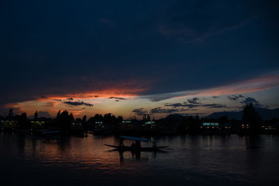 Silhouette boats in sea against sky during sunset