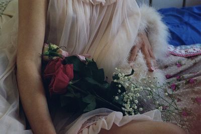 Low section of woman holding bouquet