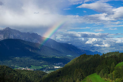 Scenic view of rainbow over mountains against sky