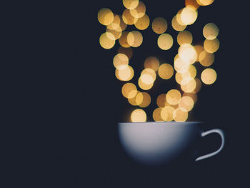 Close-up of illuminated lamp against black background