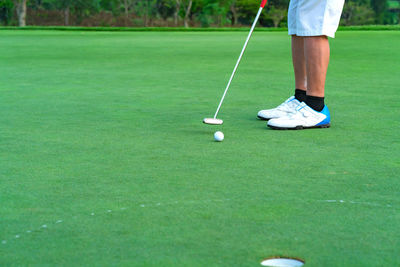 Low section of woman standing on golf ball