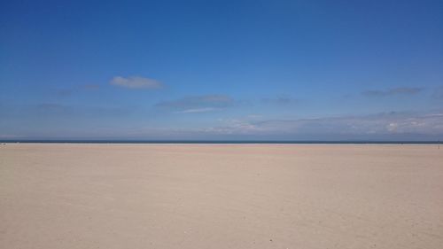 Scenic view of beach against blue sky