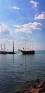 Sailboats in sea against sky