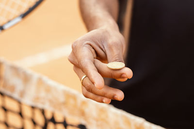 Cropped hand of man flipping coin