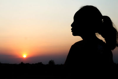 Silhouette woman standing against sky during sunset