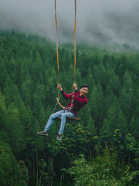 Low angle view of man jumping in forest