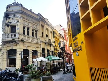 Street by buildings against sky in city