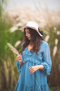 Woman wearing hat standing on field