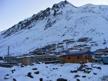 Houses on snow covered mountain against sky