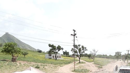Electricity pylons on landscape against sky
