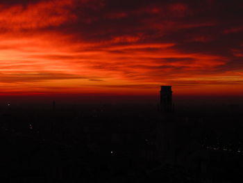 Silhouette cityscape against orange sky