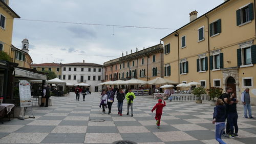 People walking on street amidst buildings in city