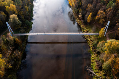 Pedestrian bridge over the river gauja near the devil cliff on a cloudy autumn day, krimulda, latvia
