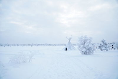 Snow covered field against sky