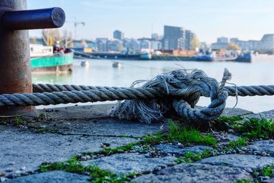 Close-up of rope tied on bollard at harbor