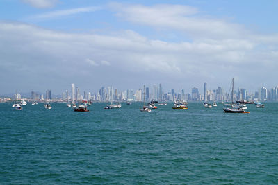 Sailboats in sea against sky