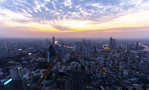 Aerial view of buildings in city during sunset