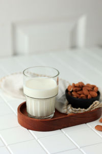 Homemade glass of almond milk on white background