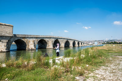 Arch bridge over river against sky