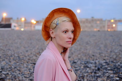 Portrait of woman standing at beach against sky