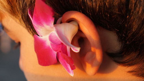 Close-up of woman with pink flower