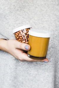 Close-up of hand holding peanut jars