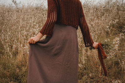 Midsection of woman standing on field