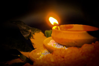 Close-up of lit candle in the dark