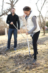 Couple raking leaves in garden, stockholm, sweden