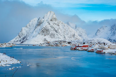 Scenic view of snowcapped mountain by sea against sky