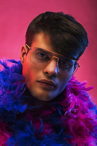 Close-up portrait of young man against red background