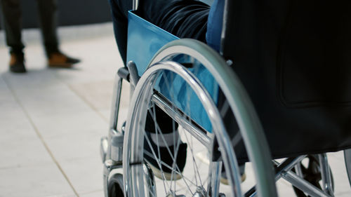 Midsection of man sitting on wheelchair