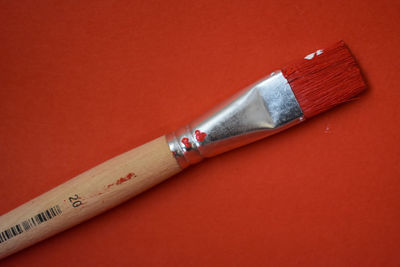 Close-up of paintbrushes against red background