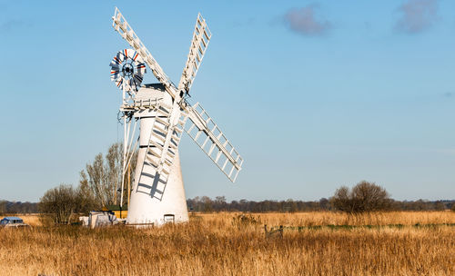 Traditional windmill on field against sky