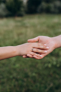 Cropped image of couple holding hands outdoors