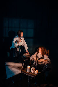 Young woman sitting on table at night