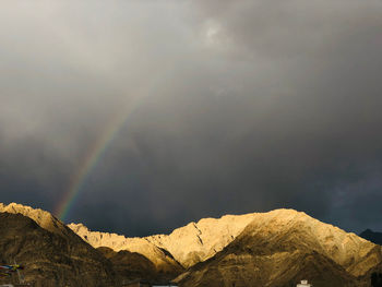 Low angle view of rainbow over mountain against sky