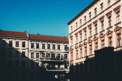 Low angle view of buildings against clear blue sky