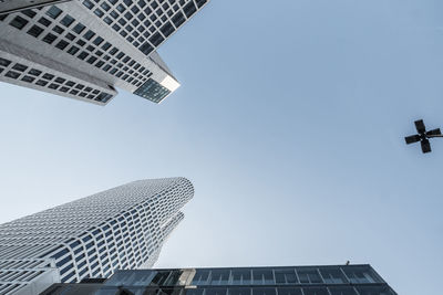 Directly below shot of modern buildings against clear sky