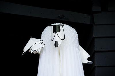 Close-up of cross hanging against white wall