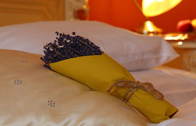 Bouquet of dry lavender flowers wrapped in paper on bed