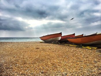 Boat moored on beach against sky