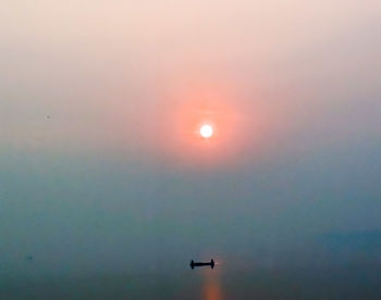 Low angle view of silhouette airplane against sky during sunset