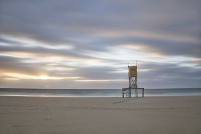 Lifeguard hut on beach against sky