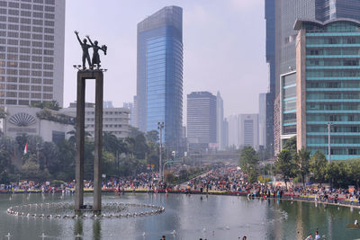 City buildings by river against sky