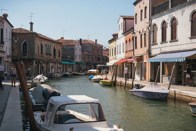 Canal amidst buildings in city against clear sky