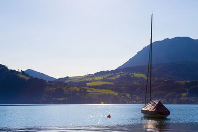 Sailboats in lake against clear sky