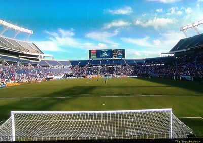 Group of people on soccer field against sky