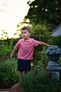 Boy looking away while standing on field